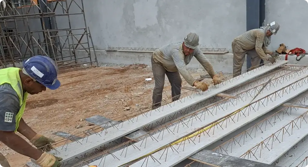 Operários manipulando a vigota painel maciço para montagem